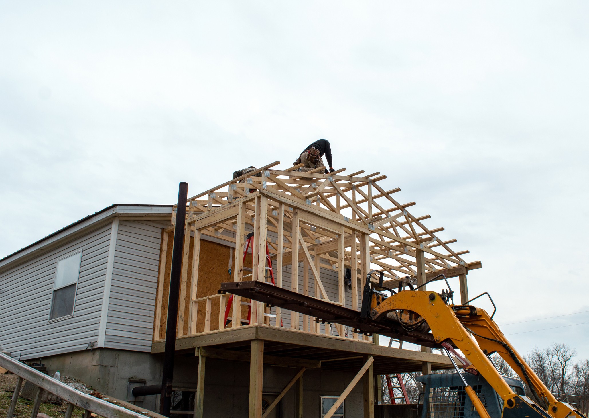 Carpenters on the roof of new building addition Budget Tips for Home Extensions in Adelaide